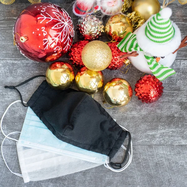 Arka planda koronavirüs olan Noel süslemeleri, Noel çorapları, yüz maskeleri ve oyuncakları olan yatay bir görüntü. Noel için Covid konsepti