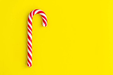 Parlak ve neşeli sarı arka planda Noel bastonu.