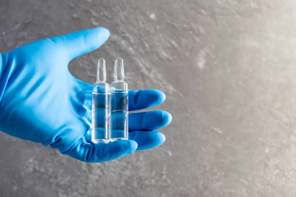 Läkare Hand Blå Gummihandske Samtidigt Hålla Medicinflaska Och Klar Vätska — Stockfoto