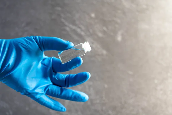 Läkare Hand Blå Gummihandske Samtidigt Hålla Medicinflaska Och Klar Vätska — Stockfoto