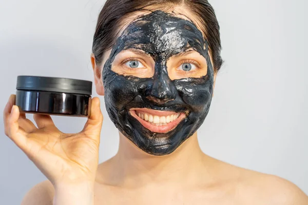 Känslomässig Kvinna Med Svart Träkol Ansikte Mask Och Lotion Grädde — Stockfoto