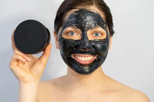 Känslomässig Kvinna Med Svart Träkol Ansikte Mask Och Lotion Grädde — Stockfoto