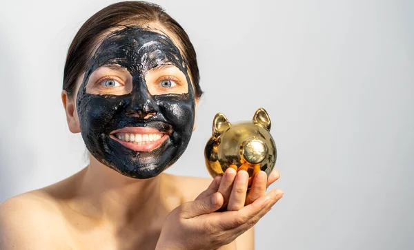 Känslomässig Kvinna Med Svart Träkol Ansikte Mask Och Med Spargris — Stockfoto