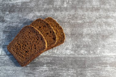 Gri ahşap arka planda organik çavdar ekmeği yemeye hazır..