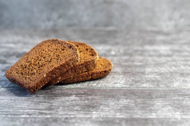 Gri ahşap arka planda organik çavdar ekmeği yemeye hazır..