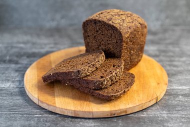 Gri ahşap arka planda organik çavdar ekmeği yemeye hazır..