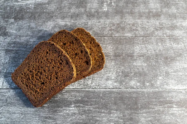 Gri ahşap arka planda organik çavdar ekmeği yemeye hazır..