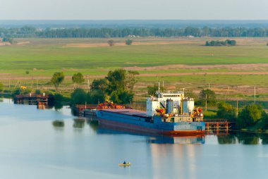 Büyük bir mavna ve nehirde bir balıkçıyla küçük bir tekne.. 
