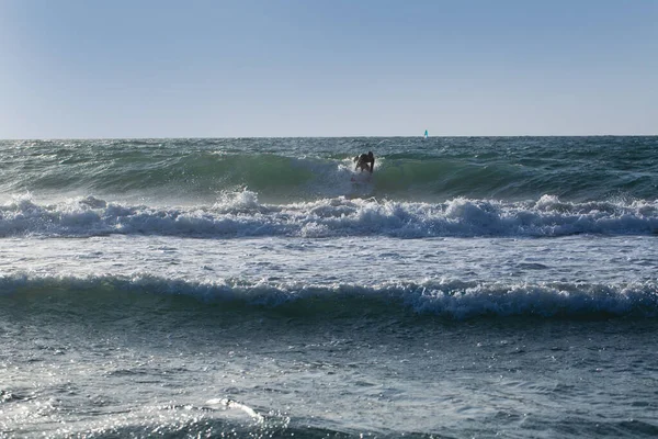 Young man surfing the wind in splashes of water. Beautiful Sea landscape. Sea Waves.