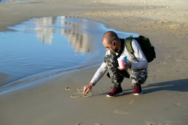 Bir adam kumun üzerine İbranice 