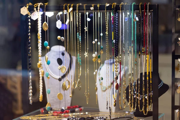 Variety of jewelry in store window. Rings, bracelets, earrings and necklaces on stands for sale. jewelry window display