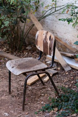 Duvara yaslanmış klasik metal koltuğun yan ve ön görüntüsü. Çocukların küçük mobilyaları duvara dayanıyor. Kopya alanı ile klasik konsept.