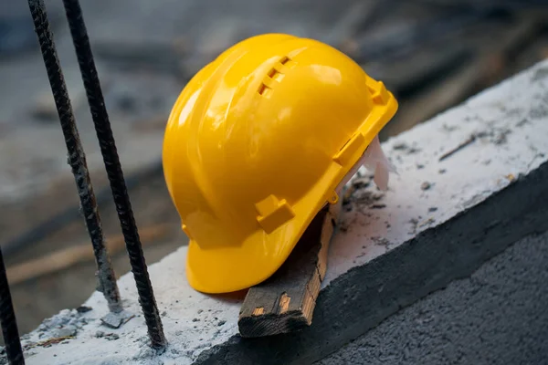 Construction hard hat safety tools equipment for workers in construction site for engineering protection head standard on building construction background. Yellow helmet.