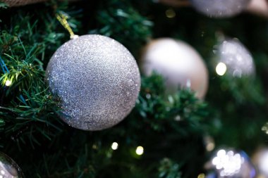Noel ağacı dallarında yılbaşı balosu, ev dekorasyonu. Bulanık arkaplanda toplarla süslenmiş Noel ağacı. 