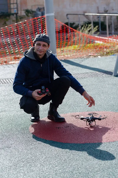 Man with remote controller in hands. Professional drone on Ground. New technology in the aero photo shooting. Man operating a drone with remote control.