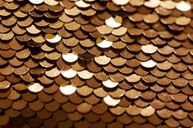 Altın payetli pulun dokusu. Şenlikli disko arkaplanı. Altın yılan derisi. Altın pulların geçmişi. Balık pulları deri dokusunun makro görüntüsü. Seçici odak, sığ derinlik alanı.