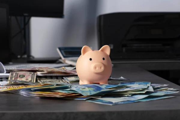 piggy bank for saving money with banknotes of Israeli New Shekels and dollars is on the table. Piggybank for saving money and business document on desk with American and Israeli money on gray desk