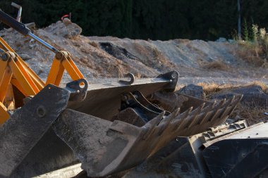 Kazı Kovası 'nı kapatın. Makine parçaları, buldozer küreğinin endüstri detayları. İnşaat sarı kazıcı kirli kova dişler. Kazı Kovası İnşaat alanında Dinleniyor