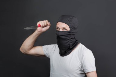 Siyah maskeli, beyaz bir adamın elindeki metal bıçak. Bıçaklı bir suçlu öldürmekle tehdit ediyor. Yazı için yeri var. Gazeteler, gazeteler, sosyal meseleler. Amerikan erkeği.