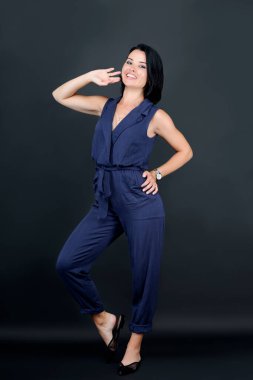 Amerikalı güzel kadın çekici, neşeli, neşeli, neşeli. Beyaz dans eden kadın gri arka planda eğleniyor. Kusursuz bir gülümseme ve sağlıklı beyaz dişlerle gülümseyen bir kız. Çekici esmer kız.