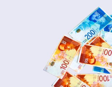 İsrail Yeni Shekels banknotları masanın üzerinde. Masanın üzerinde para var. Yığınla yeni İsrail para faturası 200 ve 100 şekel. Pankart alanı metin eklemek için maket oluşturur. Kopyalama alanı olan yan görünüm