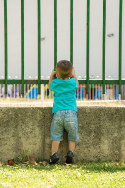 Çitin içinden bakıyorum.