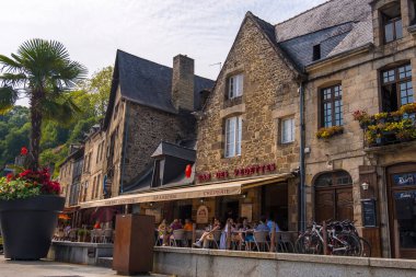 Dinan, Fransa - 26 Ağustos 2019: Turistler ve yerel halk, Dinan Limanı 'ndaki Rance Nehri kıyısındaki bir restoranda dinleniyor.