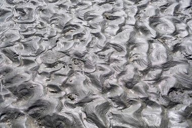 Dalgalar çekildiğinde doğal kum dokusu üzerinde parlama etkisi