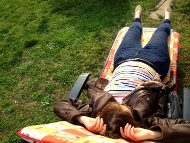 Genç kadın üzerinde parkta bir battaniyeye rahatlatıcı