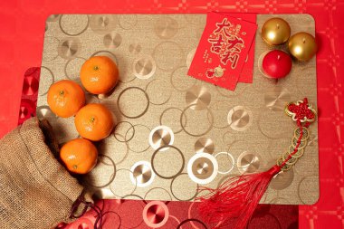 Kırmızı ve gümüş süslemeli, masa örtüsü ve mandalinalı Çin yeni yılı düzenlemesi