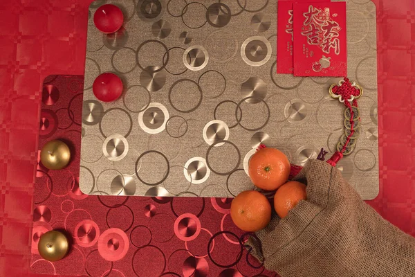 Kırmızı ve gümüş süslemeli, masa örtüsü ve mandalinalı Çin yeni yılı düzenlemesi