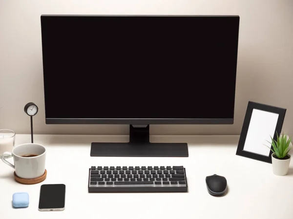 ブラッククロック付きの白いテーブルの上にワイヤレスキーボードとワイヤレスマウスを搭載したコンピュータ写真フレーム携帯電話コーヒーの白いカップ — ストック写真