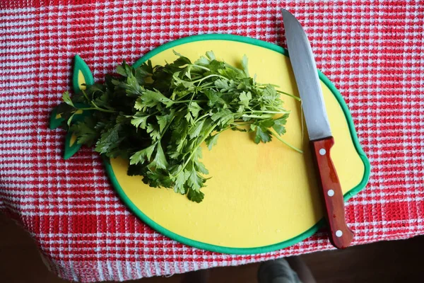 Sarı tahtada maydanoz ve bıçak.