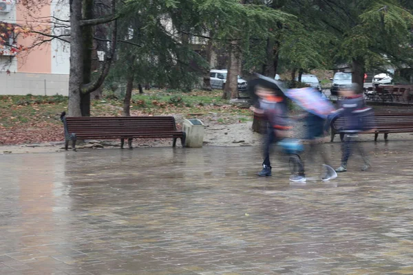 Soyut, yağmur sırasında sokaktaki insanlar