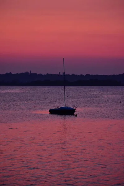 多彩的落日与海浪和帆船相映成趣 — 图库照片