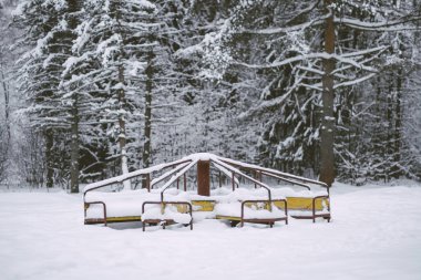  Karla kaplı terk edilmiş bir atlıkarınca çocuk oyunları olmadan yavaş yavaş yaşlanıyor ve üzülüyor.