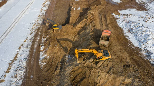 excavator loads excavated earth into a truck, construction work, top view