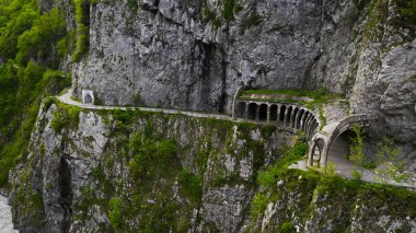 Soçi 'deki Krasnaya Polyana' ya giden eski terk edilmiş bir yol. Dağlardaki bir geçitten geçen kapalı yılan yolu..