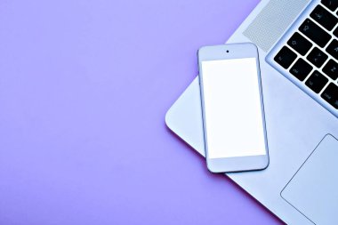 Modern pembe ofis masası ile beyaz ekranlı beyaz cep telefonunun fotokopi görüntüsü. Metni kopyalamak için dizüstü bilgisayarı var. Üst görünüm, düz yatış.