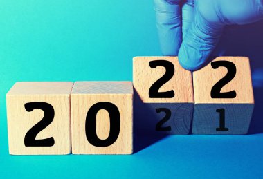 Eldiven takan el 2022 yılını ahşap küplerle değiştiriyor. Corona Virüsü ile yeni yıl kavramı