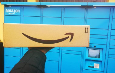 Floransa, İtalya, 26 Mart 2021. Amazon dolaplarından paket alan bir kişinin fotoğrafı. Yeni uygun self servis kavramı.