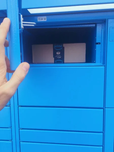 Florence, Italy, March 26th 2021, shot of a person picking up a package from the Amazon lockers, new concept of convenient self service