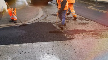 Asfalt döşeyen takım çalışanları.