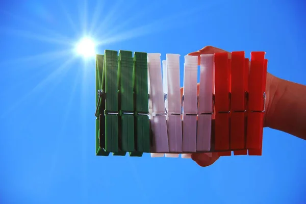 旗の色を持つ9の服ピンを持つイタリアの子供の手 背景として美しい晴れた日 — ストック写真