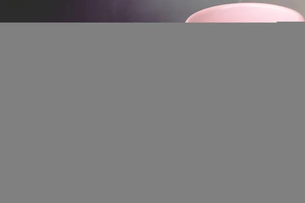 Shot Van Een Roze Beker Met Een Computer Als Achtergrond — Stockfoto