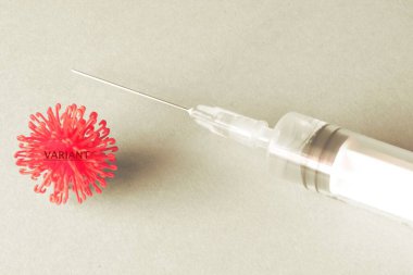Syringe in black and white with a red virus cell . Concept of Variant clipart