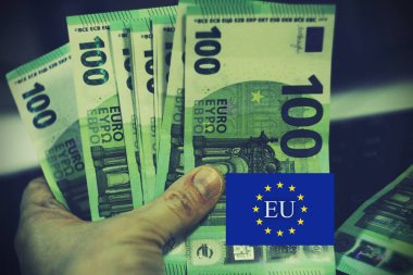 AB bayrak kaplamalı ve SFDR yazılı avro banknotları yığını. Avrupa ESG düzenlemeleri, sürdürülebilir finans ve sorumlu yatırım politikalarını temsil etmektedir