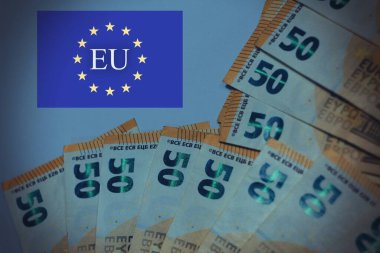 Avrupa Birliği bayrağı ve Avrupa Birliği metninin yer aldığı avro banknotları. Avrupa finans, ekonomi, siyasi birlik ve bankacılık sistemini temsil eden kavramsal imaj