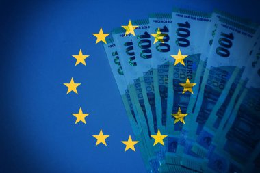 Saydam bir Avrupa Birliği bayrağı altında, sınır ötesi ticaret, ortak para birimi ve kıtasal işbirliğini temsil eden avro notlarının yer aldığı yaratıcı bir mali kompozisyon.