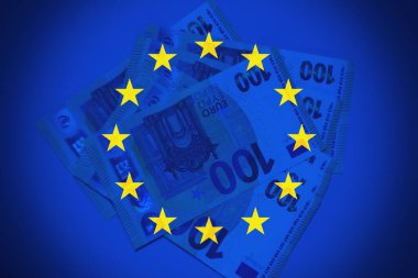 Avro banknotlarının ayrıntılı makro fotoğrafı AB bayrağı, para politikası, Avrupa yönetimi ve ortak pazarın gücünün vurgulanması.